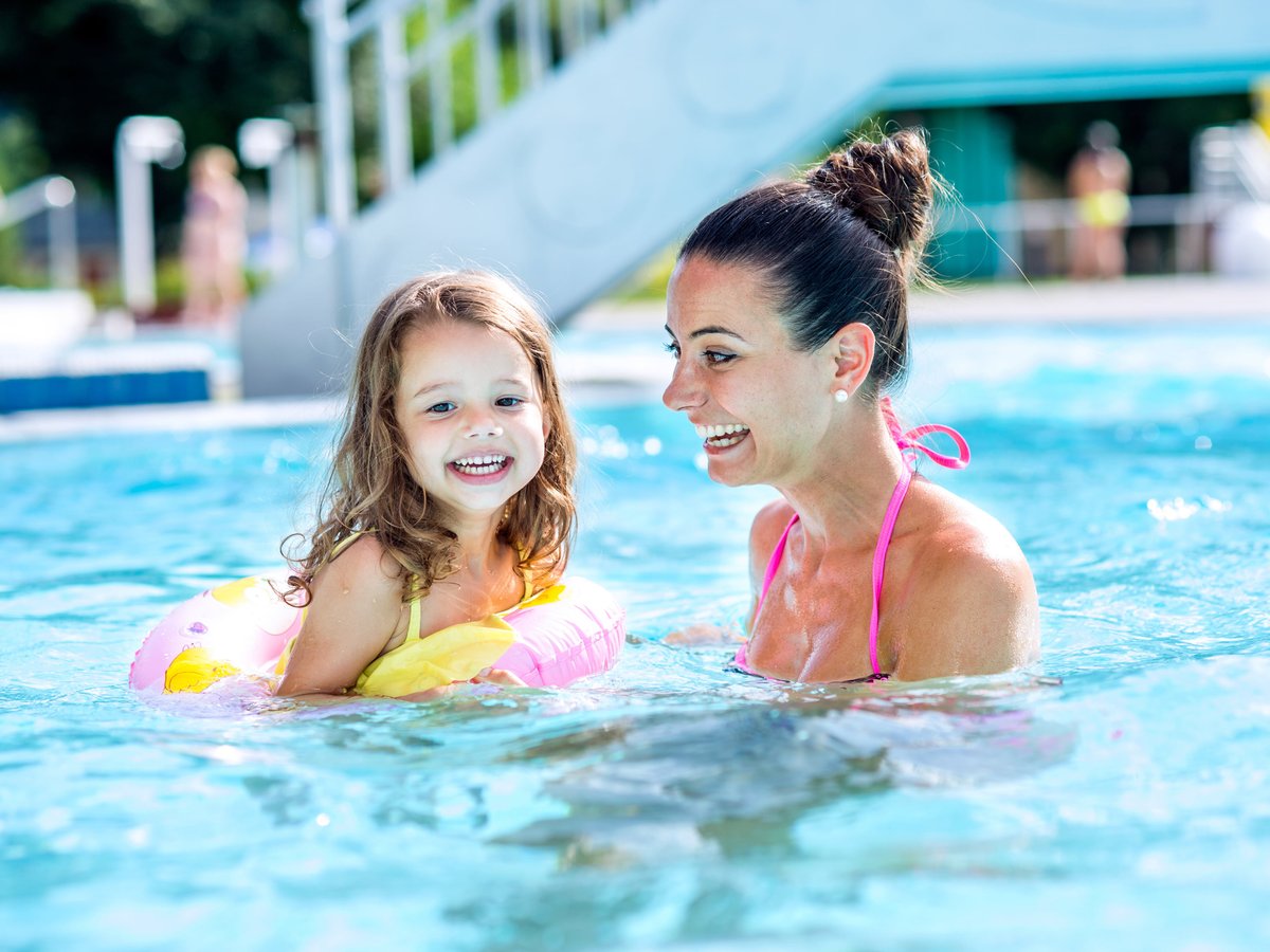 Eine Familie im Schwimmbecken eines Wasserparks